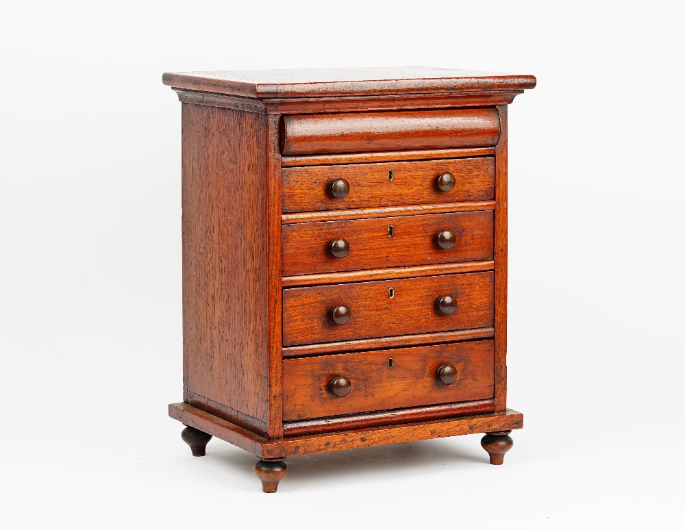 A miniature mahogany chest with a cushion drawer over four long graduated drawers on bun feet,