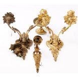 A pair of early 20th century gilt metal twin branch wall lights, decorated with ram's masks,