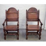 A pair of 17th century style oak panel back open armchairs on turned supports,