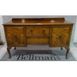 An 18th century style walnut sideboard with central drawer flanked by cupboards on cabriole