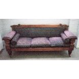 A George IV mahogany framed sofa with leaf carved back and urn arm supports on tapering reeded