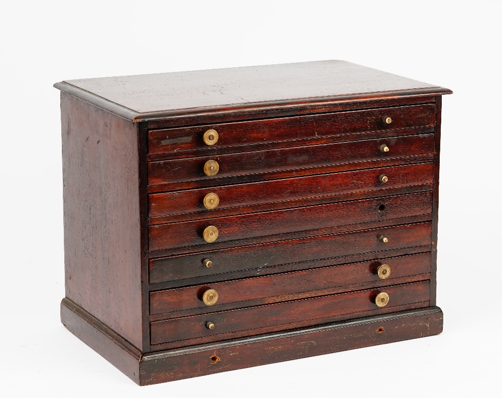 A 19th century mahogany table top collector's chest of seven long graduated drawers on a plinth