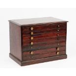 A 19th century mahogany table top collector's chest of seven long graduated drawers on a plinth
