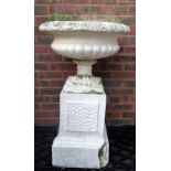 An early 20th century white painted reconstituted stone urn with egg and dart rim decoration on a