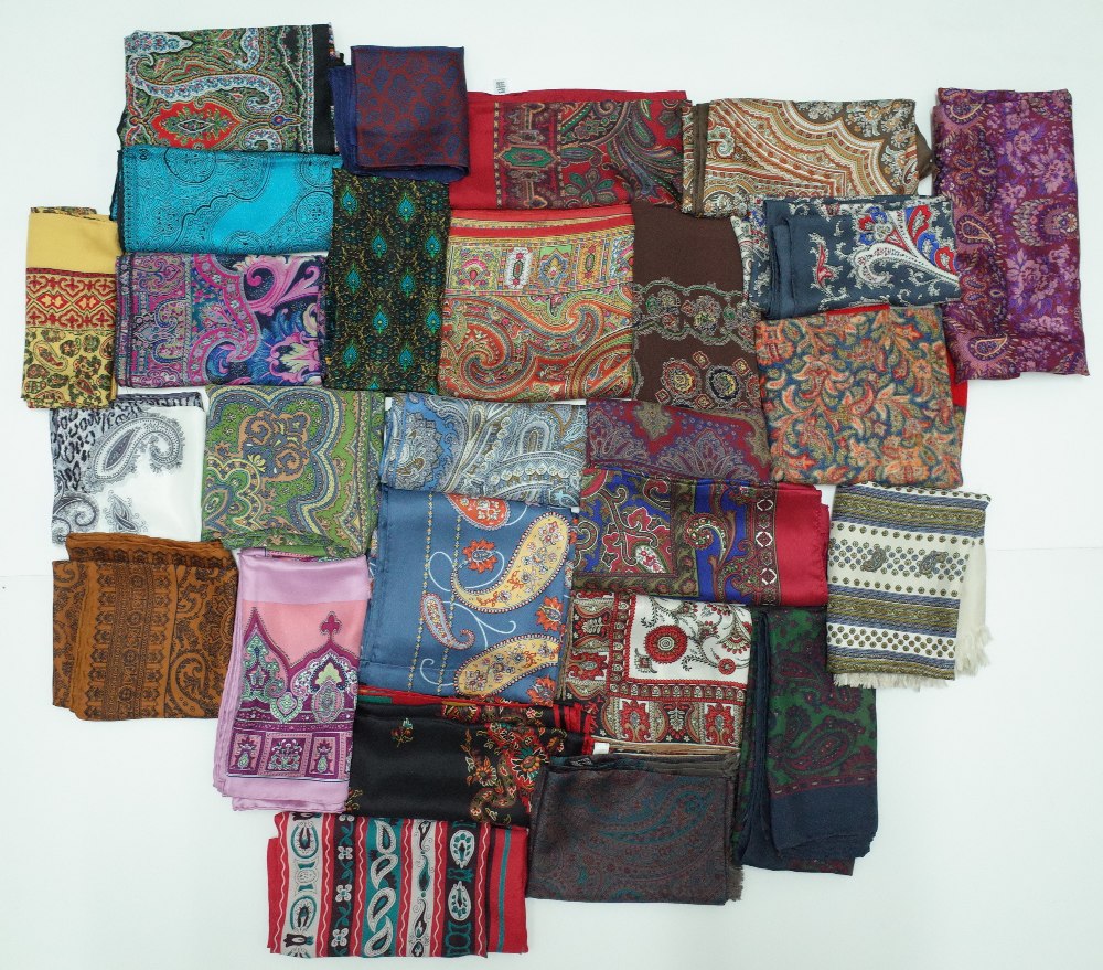 A large collection of twenty-five silk and wool scarves each printed with a paisley design,