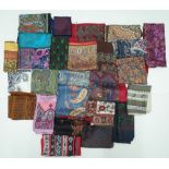 A large collection of twenty-five silk and wool scarves each printed with a paisley design,
