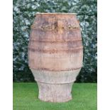 A large terracotta baluster shaped oil jar with three lug handles, 55cm wide x 87cm high, (a.f).