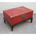 A 19th century Chinese scarlet lacquered rectangular trunk, on later ebonised stand,