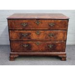 A George II featherbanded walnut chest with four long graduated drawers, on ogee bracket feet,