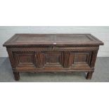 A 17th century oak coffer with twin panel lid over triple moulded panel front on stile feet,