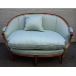 A small beech framed Louis XVI style tub back sofa on fluted supports, 135cm wide x 88cm high.