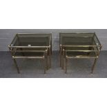 A pair of mid-20th century lacquered brass and smoked glass nest of three rectangular tables,