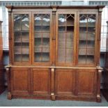 A Victorian oak Gothic revival bookcase cabinet with four arched astragal glazed doors divided by