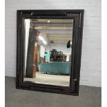 An 17th century style ebonised wall mirror with wriggle work cushion frame about the bevelled
