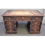 A Victorian carved oak pedestal desk with nine drawers about the knee on a plinth base,