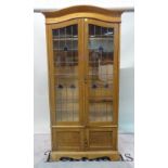 An early 20th century oak floor standing bookcase with lead lined glazed doors, over cupboard base,
