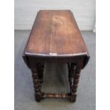 A 17th century oak drop flap dining table, the oval top on bobbin turned supports,