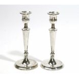 A pair of silver table candlesticks, each with a tapered stem, raised on a circular foot,