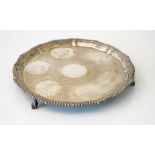 A silver salver, of shaped circular form, having a Chippendale style rim,