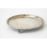 A silver waiter, of circular form decorated with a gadrooned rim, raised on three feet, London 1939,