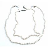A single row necklace of graduated cultured pearls, on a diamond set clasp, designed as a bow,