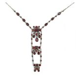 A gold and garnet pendant necklace, the front with three graduated sections, mounted with circular,