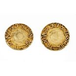A pair of yellow precious metal dress studs, applied with zodiac symbols, to a textured ground,