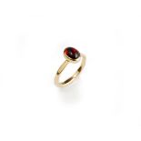 A gold ring, collet set with an oval carbuncle garnet, the shank with faceted decoration, unmarked,