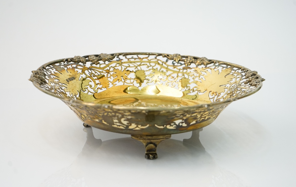 A silver gilt dish, of shaped circular form, cast and pierced with a border of fruiting vine,