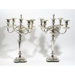 A pair of silver plated on copper five light table candelabra, with scrolling arms,