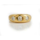 An 18ct gold and diamond three stone ring, gypsy set with a row of cushion shaped diamonds,