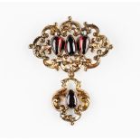 A Victorian gold and carbuncle garnet brooch, in a scroll pierced openwork design,