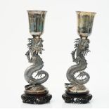 A pair of Chinese vases, each supported by an open mouthed dragon, raised on a circular base,