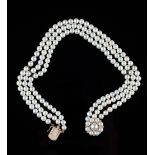 A three row necklace of cultured pearls, on a 9ct gold cultured pearl and diamond cluster clasp,