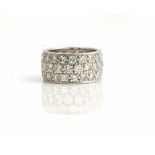 A white gold and diamond eternity band ring, mounted with three rows of circular cut diamonds,