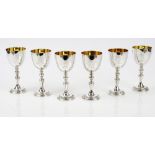 A set of six silver wine goblets, the stems and the circular bases decorated with fruiting vine,