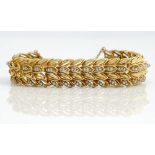 A gold and diamond bracelet, in a multiple row foliate design, mounted with circular cut diamonds,