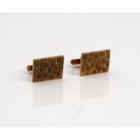 A pair of 9ct gold cufflinks, each with a rectangular front, having a textured finish,
