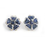 A pair of white gold, sapphire and diamond earclips, each designed as a flowerhead,