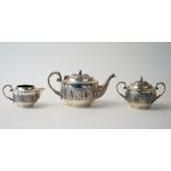 An Indian three piece tea set, comprising; a teapot, the hinged lid with an elephant finial,