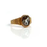 A Victorian gold and oval cameo ring, the mount decorated with engraved tapered panels,