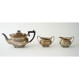 A silver three piece tea set comprising; a teapot, a twin handled sugar bowl and a milk jug,