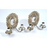 A pair of silver twin light candle wall sconces, the back plates of shaped oval form,