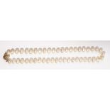 A single row baroque cultured pearl necklace, suspended from a diamond-set spherical gold clasp,