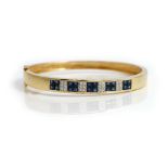 A French gold, sapphire and diamond set oval hinged bangle,