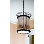 A cylindrical black metal and tubular glass pendant light fitting, of four lights, 50cm high.