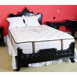 A black lacquered double bed, in Chinese Chippendale style, with shaped headboard and footboard,