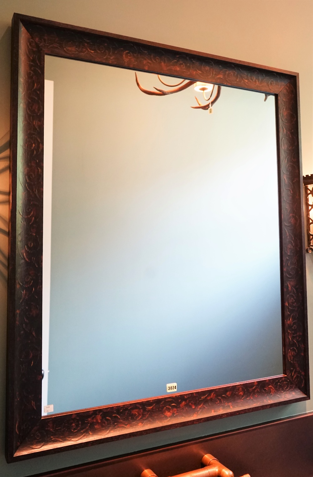 A rectangular wall mirror in 17th century style, the distressed frame with scrolling branches,