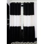 A pair of graphic black and white linen curtains, the lower panels with dress maker's pleats,