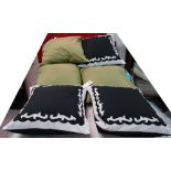 Three large black and white cushions, and three large green cushions,